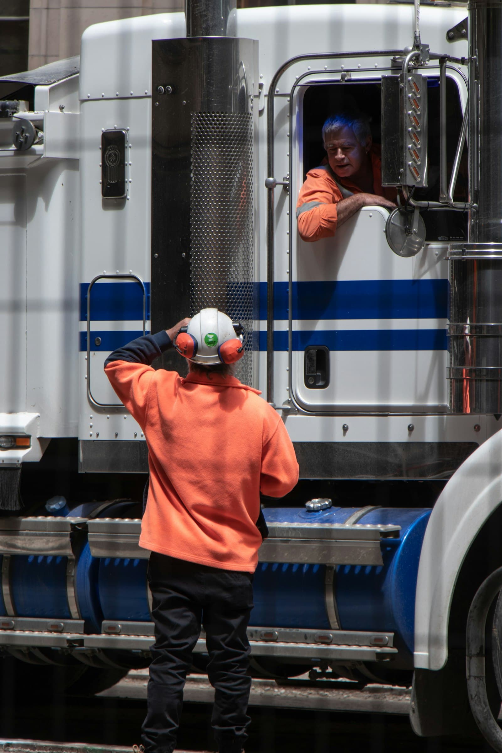 Professional CDL truck driver in the cab of a white semi truck