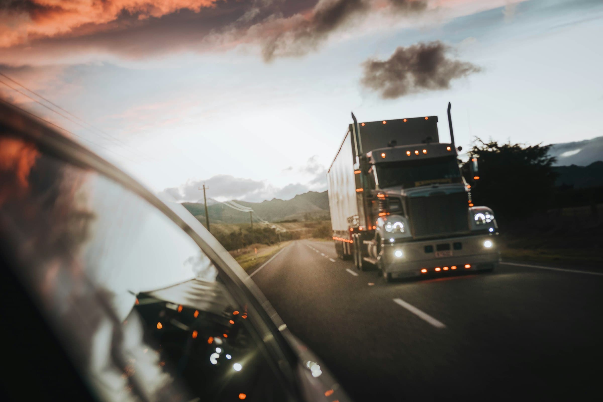 Semi truck driving down the highway at sunset – OTR Recruit truck driver recruiting